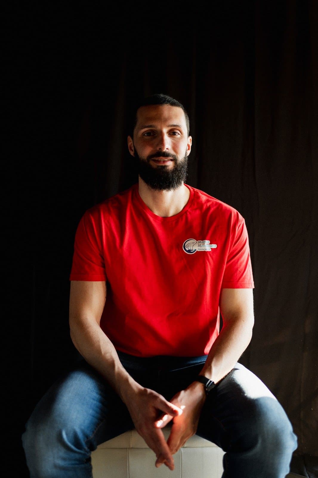 Il Dott. Matteo Montanaro con la maglietta rossa nel suo studio di Tortona