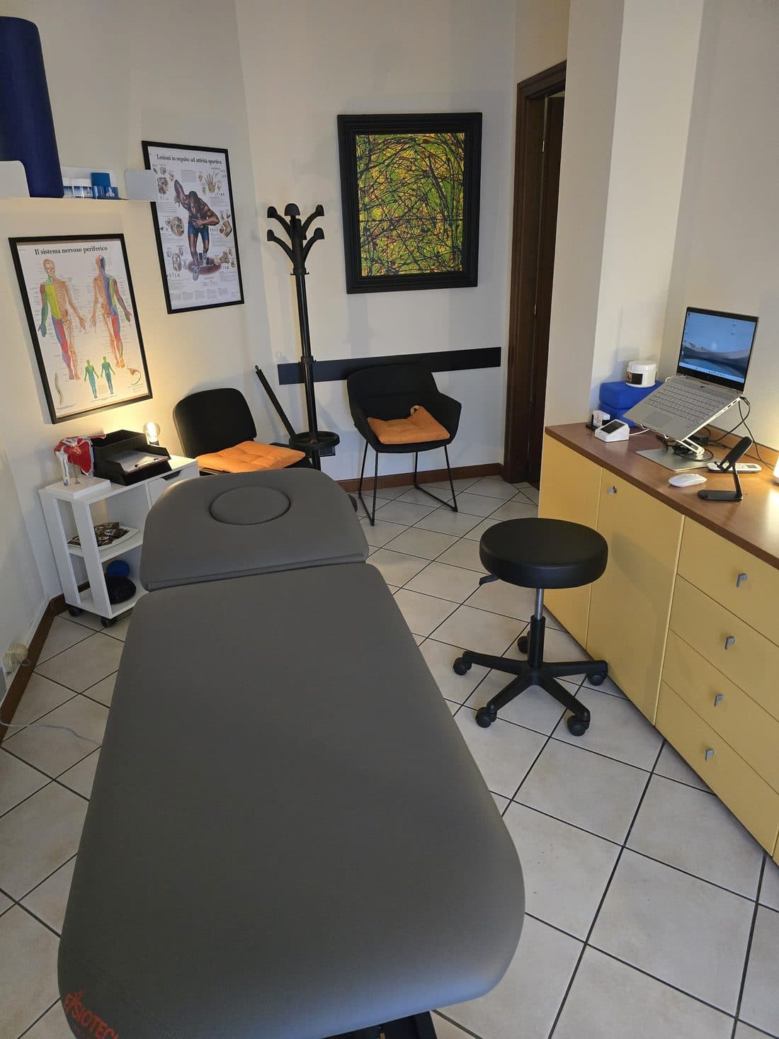 La stanza dei trattamenti dello studio: lettino, tavole anatomiche e postazione di lavoro